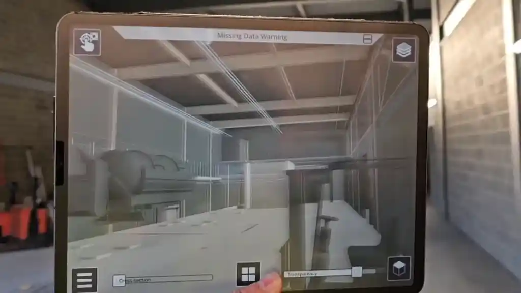 MEP model overlaid on a live site through a tablet, cross-sectioned with missing data flagged